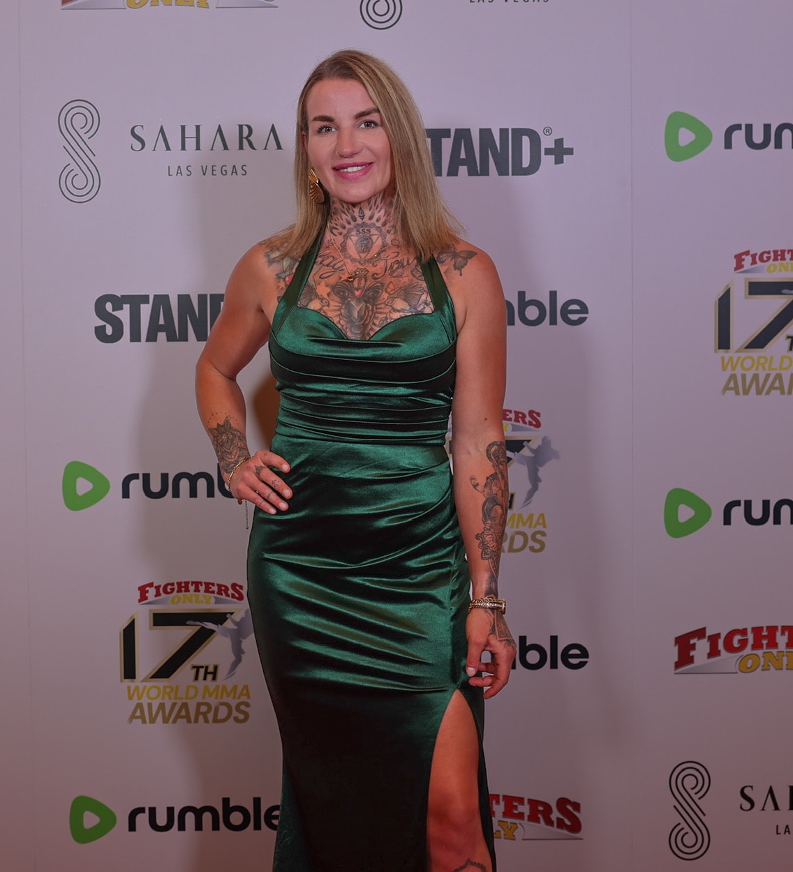 Woman in emerald green satin dress on the red carpet at the MMA Awards